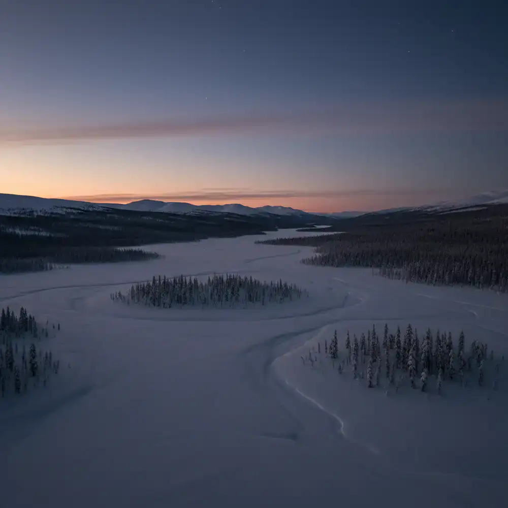 Wide boreal basin under a twilight winter sky